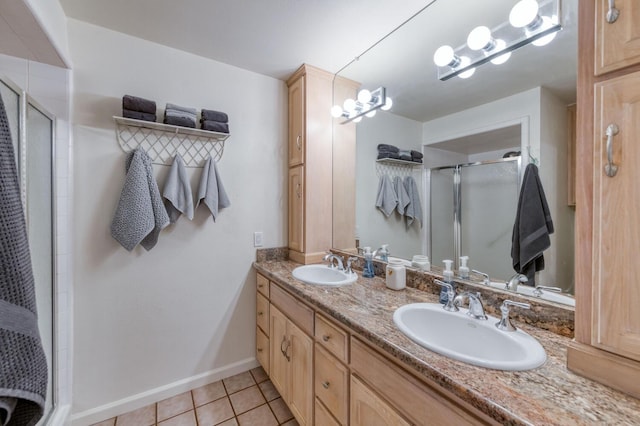 bathroom with double vanity, tile patterned flooring, a stall shower, and a sink