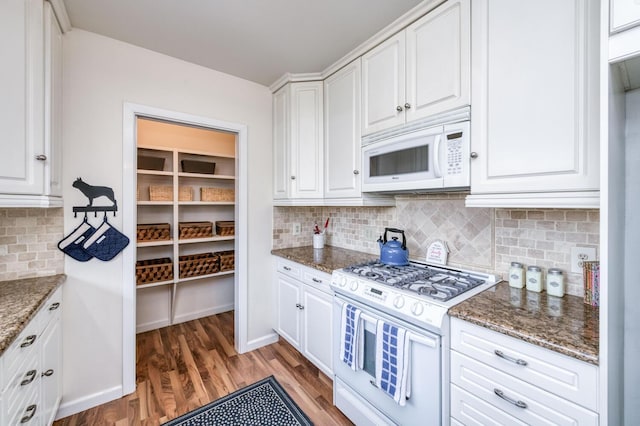 kitchen featuring light wood finished floors, white appliances, white cabinetry, and tasteful backsplash