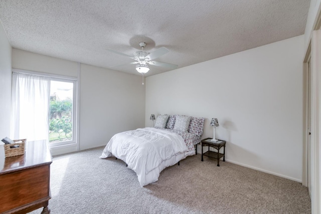 carpeted bedroom featuring a textured ceiling and a ceiling fan