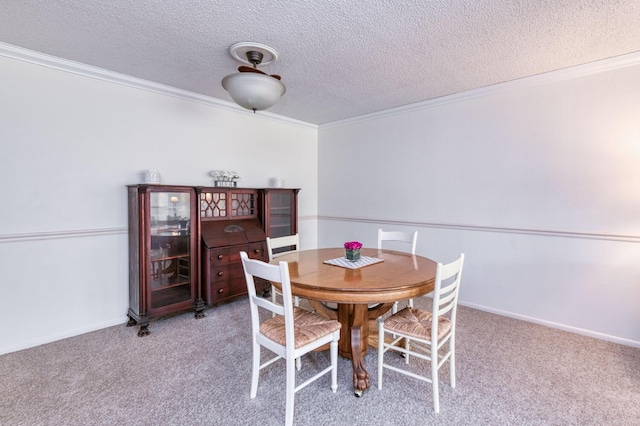 carpeted dining room with baseboards, a textured ceiling, and ornamental molding