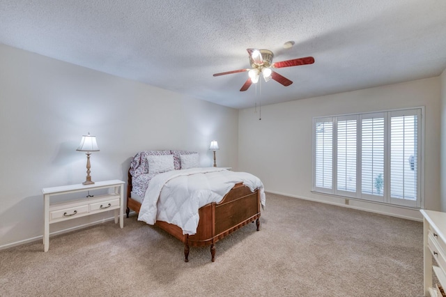 bedroom with a textured ceiling, carpet flooring, baseboards, and ceiling fan