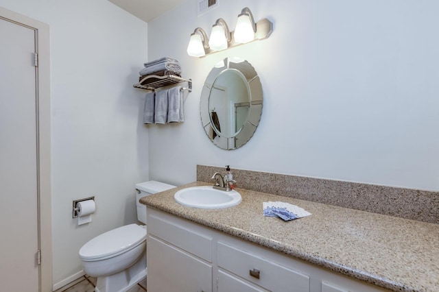 bathroom featuring toilet, vanity, and visible vents