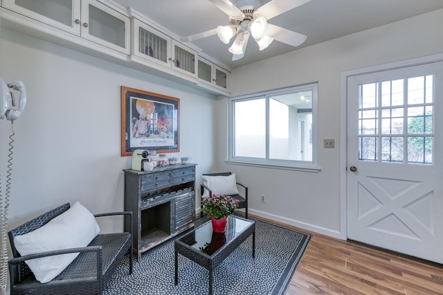 interior space featuring light wood-style flooring, a ceiling fan, and baseboards