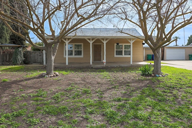 view of front of house with an outbuilding, a porch, a garage, and fence