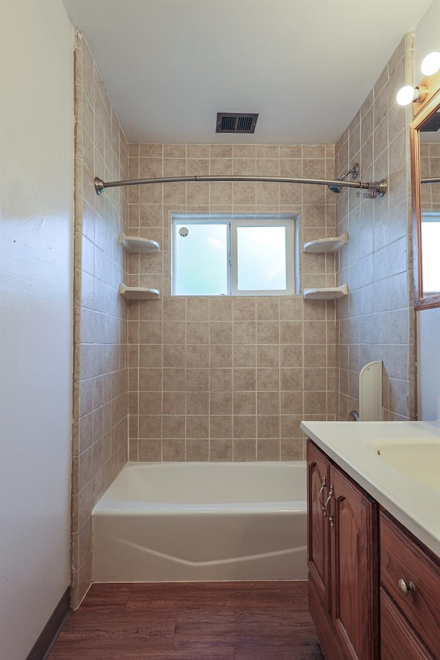 full bath with vanity, bathing tub / shower combination, wood finished floors, and visible vents