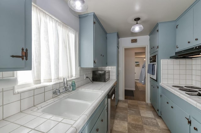 kitchen featuring sink, blue cabinets, and tile countertops