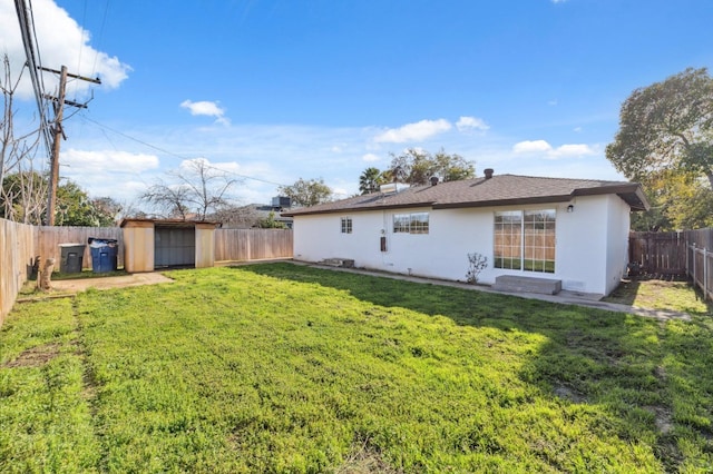 back of house featuring a lawn and a storage shed