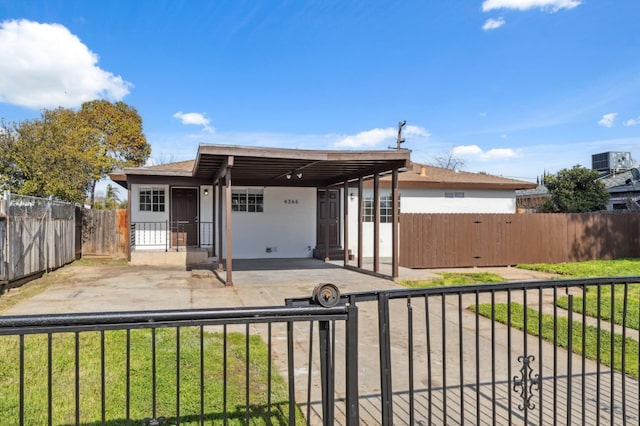 view of front of property featuring central AC and a carport