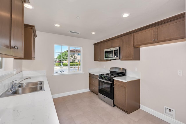 208 E Florence Ave, Fresno, CA 93706 - kitchen with baseboards, gas stove, visible vents, a sink, and stainless steel microwave
