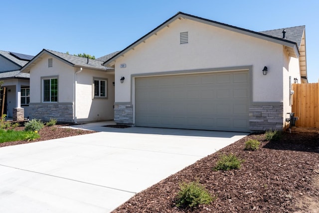 208 E Florence Ave, Fresno, CA 93706 - view of front of home featuring concrete driveway, a garage, stucco siding, and stone siding