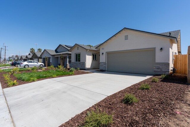 208 E Florence Ave, Fresno, CA 93706 - ranch-style home with stone siding, an attached garage, stucco siding, fence, and concrete driveway