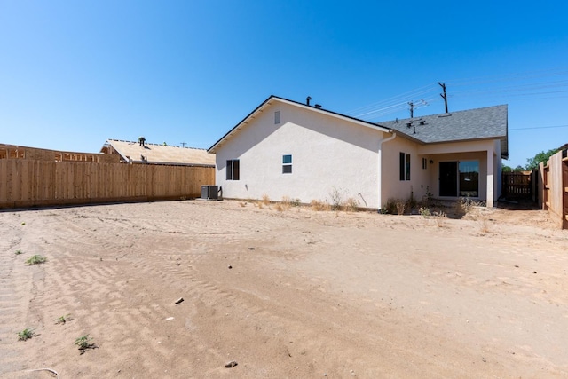208 E Florence Ave, Fresno, CA 93706 - rear view of house with stucco siding, roof with shingles, a fenced backyard, and central AC