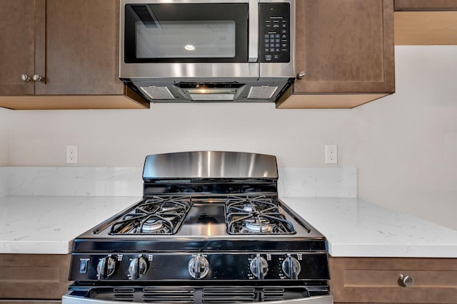 208 E Florence Ave, Fresno, CA 93706 - kitchen featuring stainless steel microwave, light stone countertops, and black range with gas stovetop