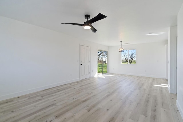 empty room with ceiling fan and light hardwood / wood-style flooring