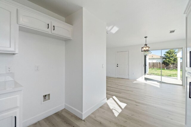 kitchen featuring white cabinetry, light hardwood / wood-style flooring, and decorative light fixtures