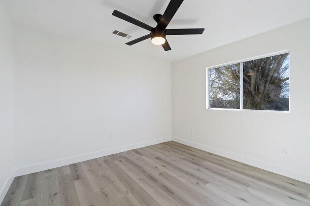 empty room with ceiling fan and light hardwood / wood-style flooring