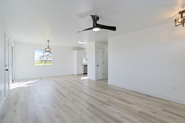 unfurnished living room with ceiling fan with notable chandelier and light hardwood / wood-style flooring