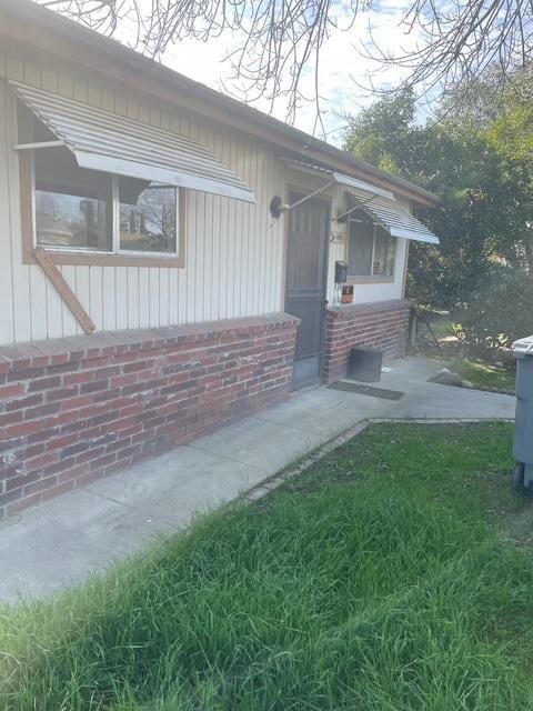 property entrance featuring a lawn