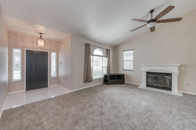 foyer with ceiling fan, vaulted ceiling, and light colored carpet