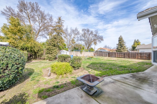 view of yard featuring a storage unit, a patio, and an outdoor fire pit