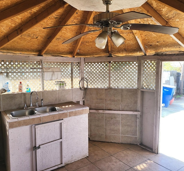 exterior space featuring ceiling fan, sink, light tile patterned floors, and lofted ceiling