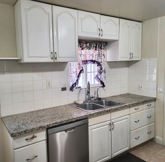 kitchen featuring stainless steel dishwasher, decorative backsplash, sink, and white cabinets