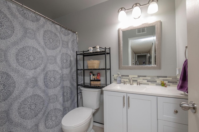 bathroom with toilet, backsplash, and vanity