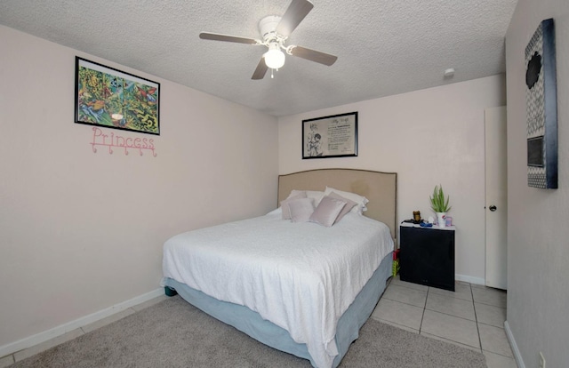 bedroom featuring ceiling fan, light tile patterned flooring, and a textured ceiling