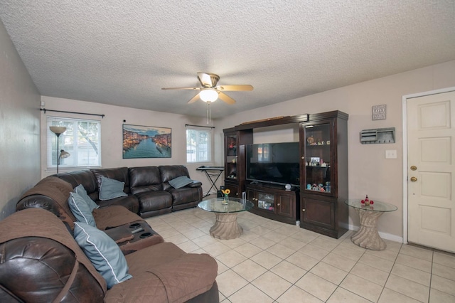 living room featuring a textured ceiling, ceiling fan, and light tile patterned floors