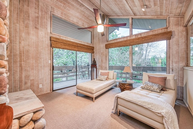 interior space with lofted ceiling, ceiling fan, wood ceiling, and plenty of natural light