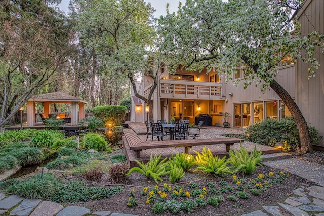 rear view of property with a gazebo and a balcony