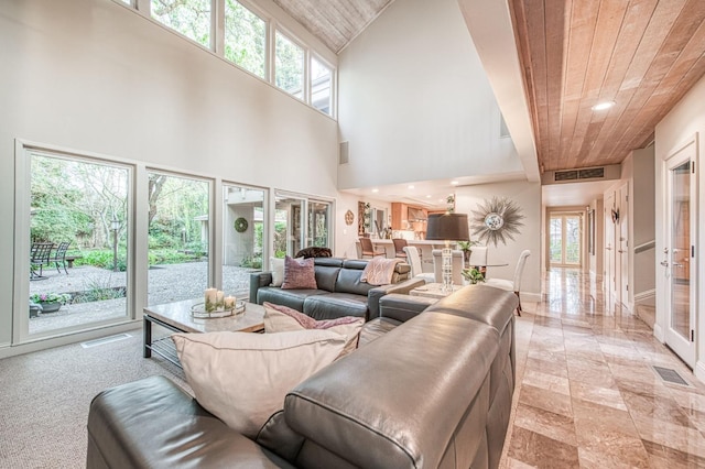 living room with french doors, a towering ceiling, and wooden ceiling