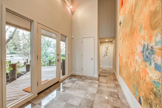 doorway featuring a high ceiling and a healthy amount of sunlight