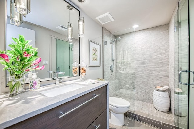 bathroom with tile patterned floors, toilet, vanity, and walk in shower