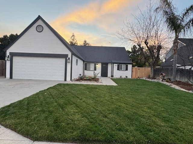 single story home featuring a garage and a lawn