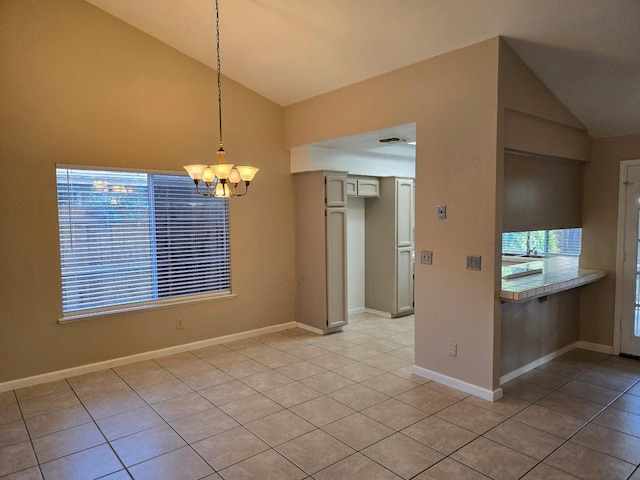 unfurnished dining area with a notable chandelier, light tile patterned flooring, and vaulted ceiling