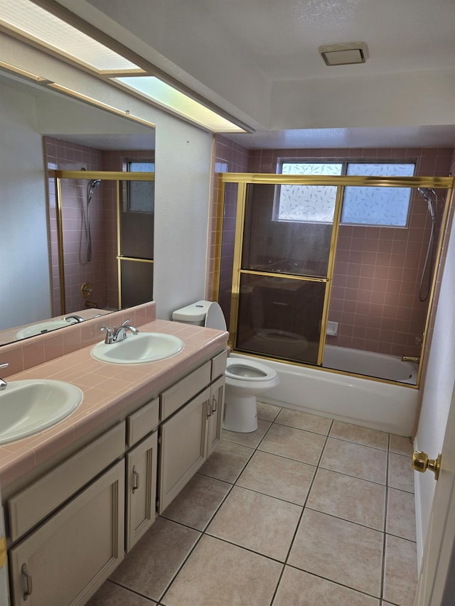 full bathroom featuring toilet, tile patterned flooring, vanity, and enclosed tub / shower combo
