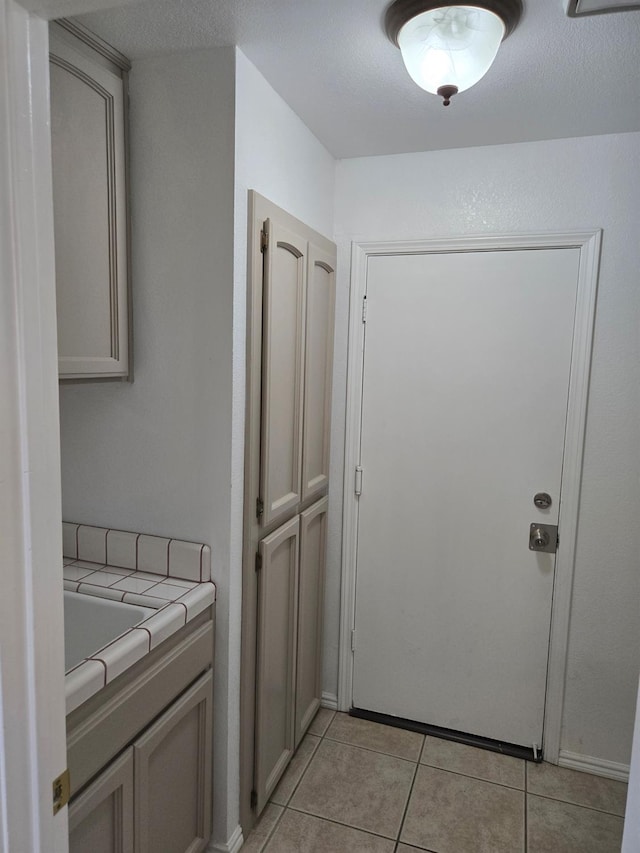 laundry room with light tile patterned flooring and a textured ceiling