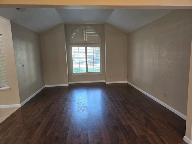 bonus room with dark wood-type flooring and lofted ceiling