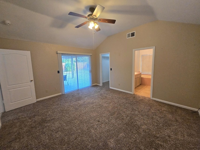 unfurnished bedroom featuring connected bathroom, vaulted ceiling, ceiling fan, a spacious closet, and carpet flooring