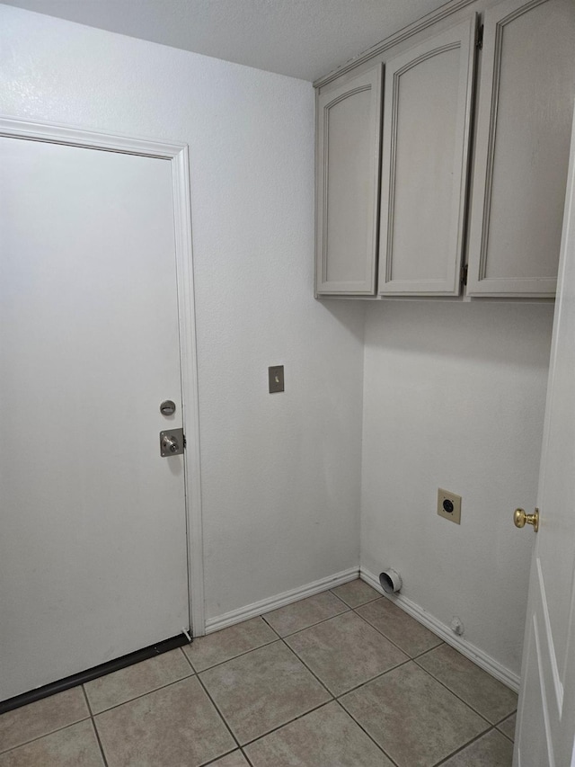 clothes washing area featuring light tile patterned flooring, cabinets, and electric dryer hookup