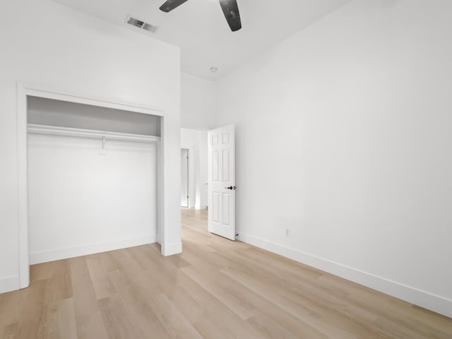 unfurnished bedroom featuring light hardwood / wood-style flooring, ceiling fan, and a closet