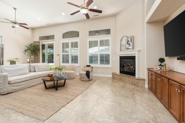 living room featuring ceiling fan and a towering ceiling