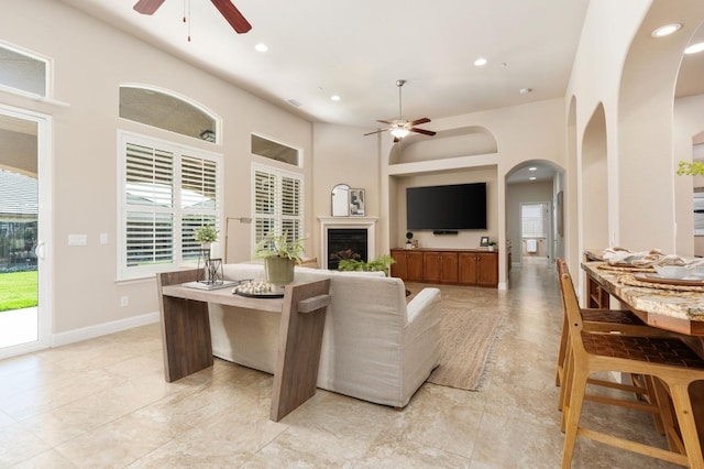 living room with ceiling fan and a high ceiling