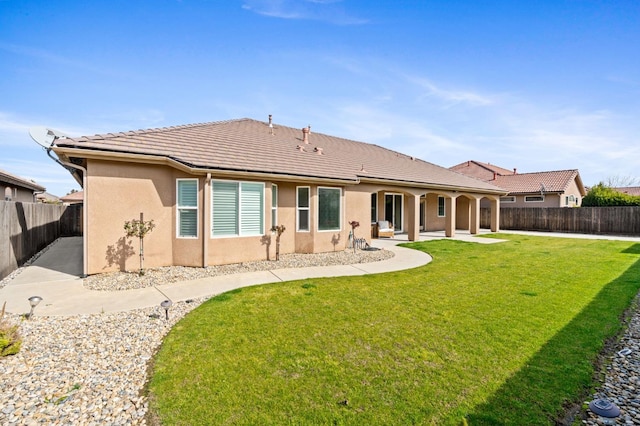 rear view of house featuring a patio area and a lawn