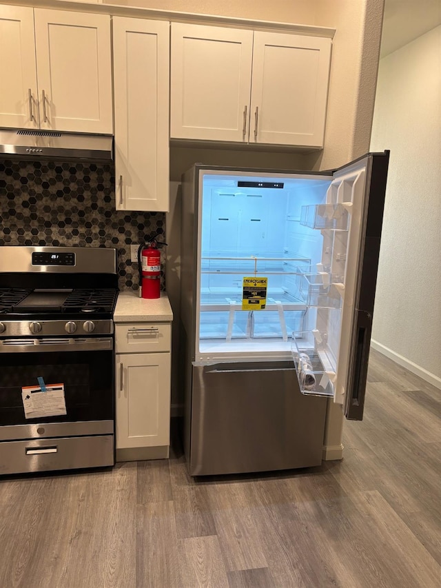 kitchen featuring decorative backsplash, light hardwood / wood-style floors, stainless steel appliances, and white cabinets