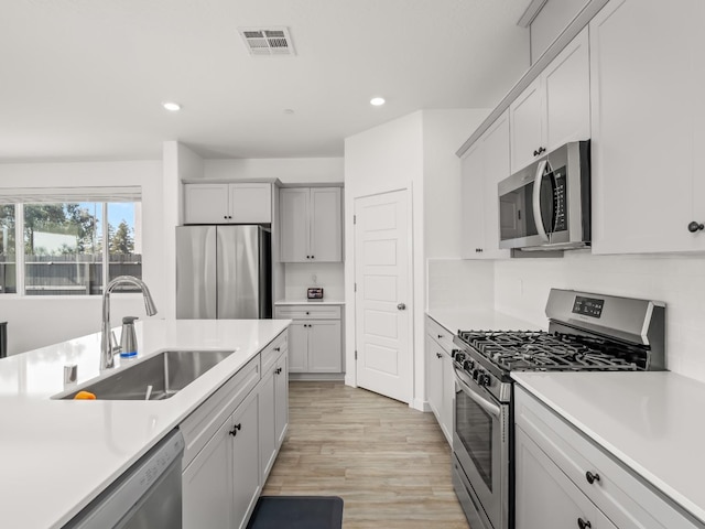 kitchen with sink, appliances with stainless steel finishes, and light wood-type flooring