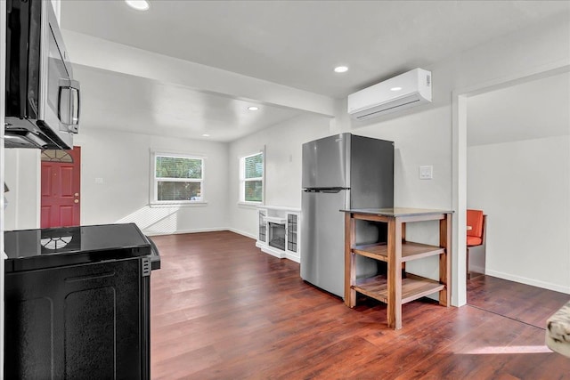 kitchen featuring an AC wall unit, stainless steel appliances, and dark wood-type flooring