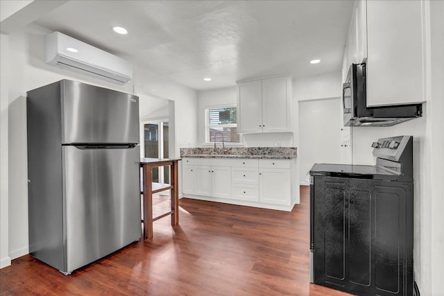 kitchen featuring sink, dark hardwood / wood-style flooring, stainless steel fridge, white cabinets, and a wall mounted AC