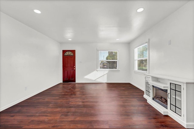 unfurnished living room with dark hardwood / wood-style flooring